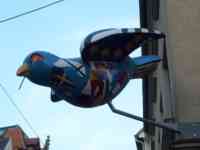 Sculpture of blue sparrow painted with flags in shapes of land masses on a globe