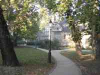 Path, lamp, trees, and buildings in city park