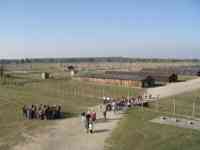 View from about 30 feet in air of barracks, fences, and ruins of numerous buildings