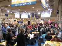 Large room filled with people and tables and game publishers