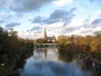 Long view of Münster behind Danube lined with autumn trees